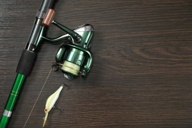 Makaralı olta ve koyu ahşap arka planda yem, üst manzara. Metin için boşluk