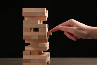 Masada siyah arka planda Jenga oynayan kadın, yakın plan