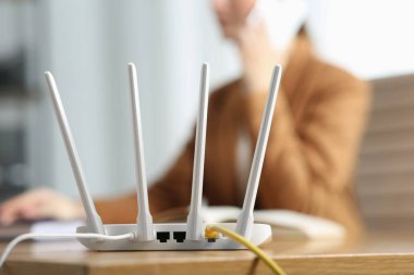 İçerideki masada akıllı telefondan konuşan kadın, Wi-Fi yönlendiricisine odaklan.