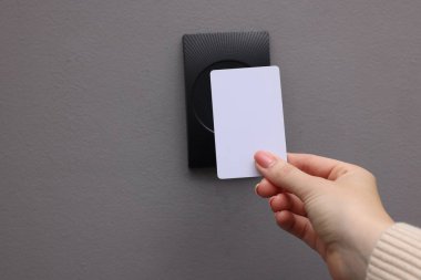 Kadın anahtar kartla manyetik kapı kilidini açıyor, yakın çekim ve mesaj için boşluk. Ev güvenliği