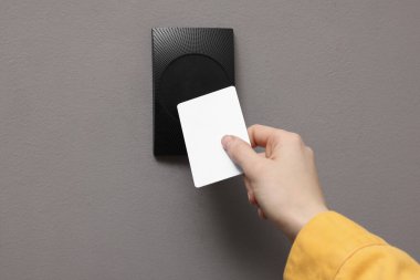 Kadın manyetik kapı kilidini anahtar kartıyla açıyor, yakın plan. Ev güvenliği