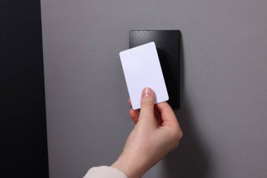 Kadın manyetik kapı kilidini anahtar kartıyla açıyor, yakın plan. Ev güvenliği