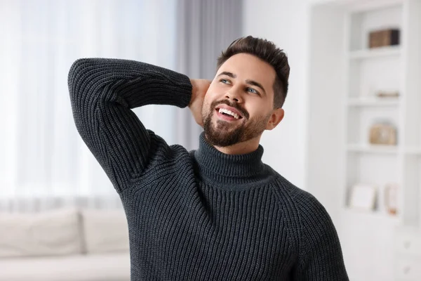 Happy man in stylish sweater at home