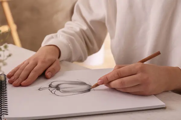 テーブルのスケッチブックでグラファイト鉛筆でベルペッパーを描いた女性 クローズアップ — ストック写真