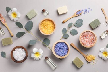 Gri arkaplanda spa ürünleri ve okaliptüs dallarıyla düz kompozisyon