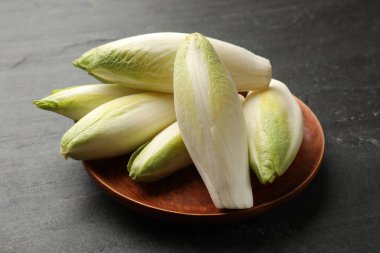 Siyah masada taze çiğ Belçika hindibaları (chicory)
