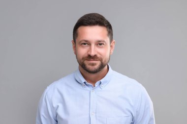 Kameraya gri arka plan üzerinde görünen adam portresi