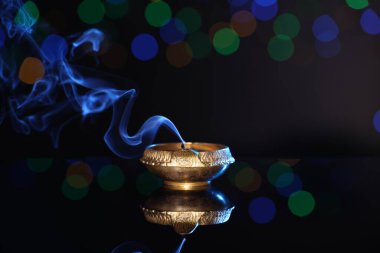 Karanlık arka planda bulanık ışıklarla havaya uçurulmuş, mesaj için yer açılmış. Diwali lambası