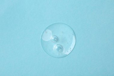 Açık mavi arkaplanda kozmetik serumu örneği, üst görünüm