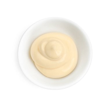 Taze mayonez sosu kabın içinde, beyaz manzarada izole edilmiş.