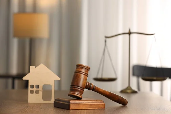 Law concept. Gavel and figure of house on wooden table
