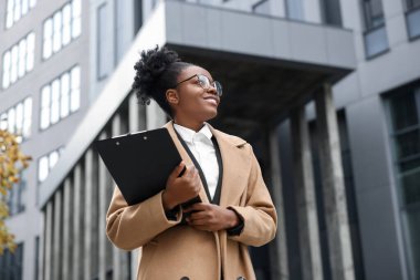Dışarıda panosu olan mutlu bir kadın. Avukat, iş kadını, muhasebeci ya da müdür.