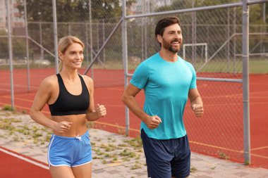 Sağlıklı bir yaşam tarzı. Stadyumda koşan mutlu çift