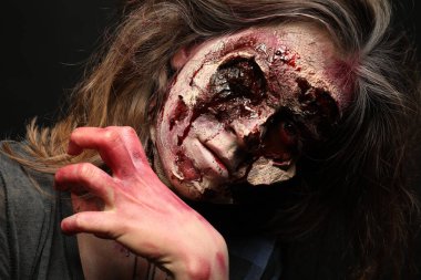 Karanlık arka planda korkunç bir zombi, yakın plan. Cadılar Bayramı canavarı
