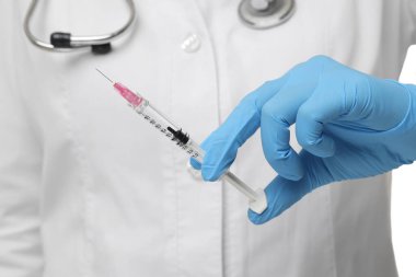 Doktor şırıngayı iğneyle tutuyor, yakın çekim.