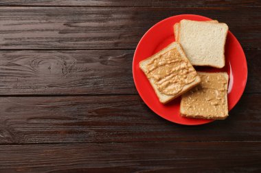 Koyu ahşap masada fıstık ezmeli leziz tostlar, üst manzara. Metin için boşluk