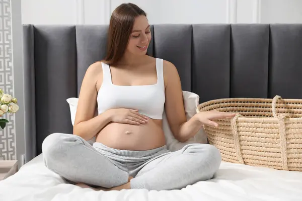 Όμορφη Έγκυος Γυναίκα Καλάθι Μωρό Στο Κρεβάτι Εσωτερικούς Χώρους — Φωτογραφία Αρχείου