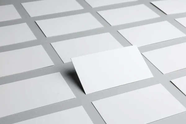 Blank business cards on light gray background, closeup. Mockup for design
