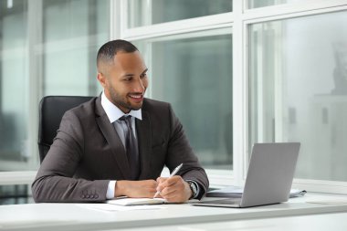 Ofisteki masada çalışan mutlu adam. Avukat, işadamı, muhasebeci ya da yönetici.