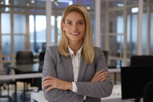 Smiling woman with crossed arms in office. Lawyer, businesswoman, accountant or manager