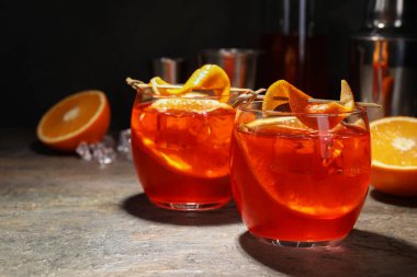 Aperol sprey kokteyli, buz küpleri ve gri desenli masada portakal dilimleri, yakın plan. Metin için boşluk