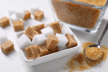 Beyaz masadaki şekerli kaseler ve kaşıklar, yakın plan.