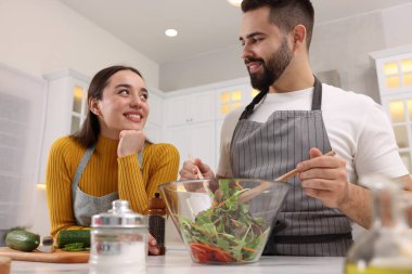 Mutfakta birlikte yemek pişiren sevimli çift, düşük açılı manzara.