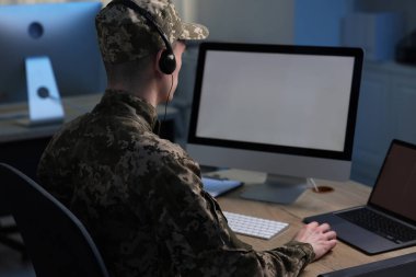 Askerlik. Kulaklıklı asker geceleri ofiste çalışıyor.