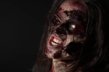 Karanlık arka planda korkunç bir zombi, yakın plan. Cadılar Bayramı canavarı