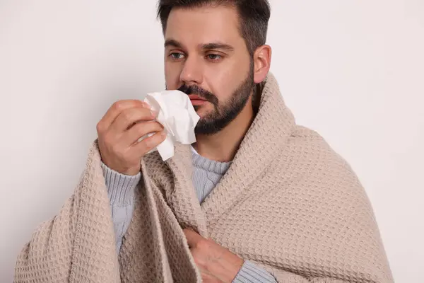 Hombre Enfermo Envuelto Manta Con Tejido Sobre Fondo Gris Claro —  Fotos de Stock