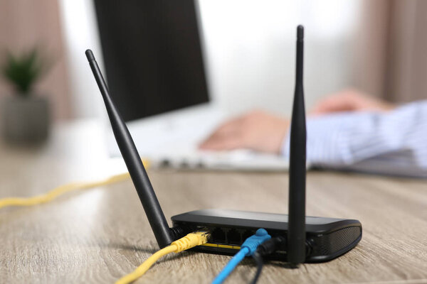 Женщина работает с ноутбуком за столом в помещении, сосредоточиться на Wi-Fi роутер