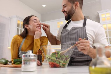 Mutfakta birlikte yemek pişiren sevimli çift, düşük açılı manzara.