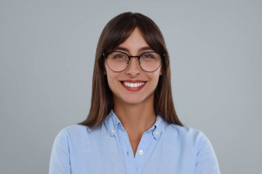 Açık gri arkaplanda mutlu sekreter portresi