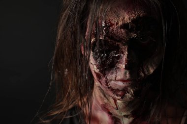 Karanlık arka planda korkunç bir zombi, yakın plan. Cadılar Bayramı canavarı