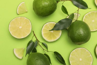 Açık yeşil zemin üzerinde limon ve yapraklar, düz uzanmış