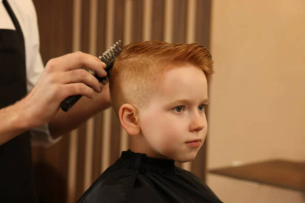 美容院 クローズアップで男の子の髪をブラッシングプロの美容師 — ストック写真
