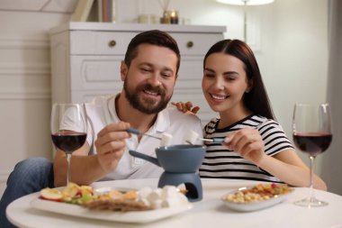 Sevgili çift evde romantik bir buluşmada fondü yiyor.