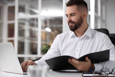 Ofiste çalışan gülümseyen adam. Avukat, işadamı, muhasebeci ya da yönetici.