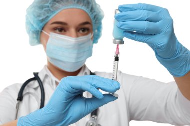 Doktor şırıngayı beyaz arka planda cam şişeden alınan ilaçlarla dolduruyor.