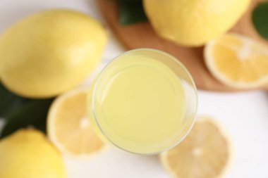 Lezzetli limoncello, limon ve yeşil yapraklı likör bardağı.