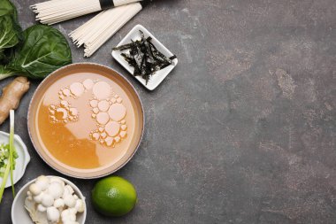 Lezzetli ramen çorbası yapıyorum. Gri masadaki farklı malzemeler. Metin için boşluk