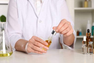 Dermatolog beyaz masada kozmetik yağı geliştiriyor.