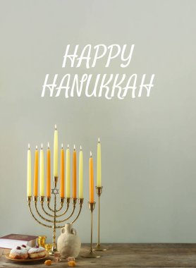 Mutlu Hanukkah. Menorah, çörekler ve eşyalar ahşap masada.