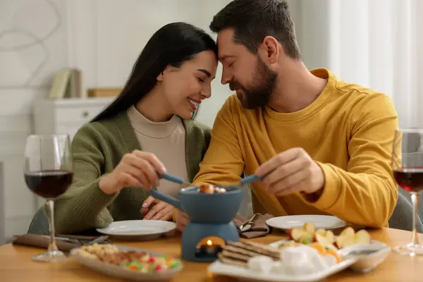 Fondüyle romantik bir randevu. Evde birbirini seven bir çift.