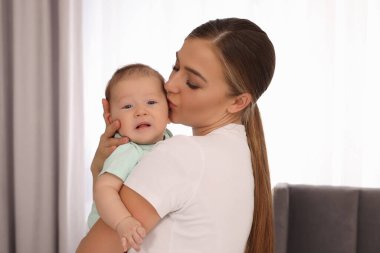 Anne yeni doğmuş bebeğini kucağında tutuyor.