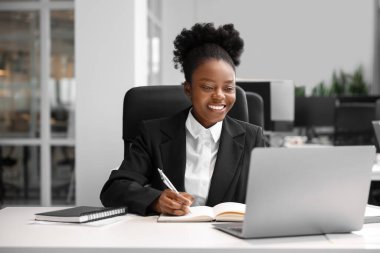 Ofisteki masada çalışan mutlu kadın. Avukat, iş kadını, muhasebeci ya da müdür.