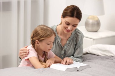 Kız ve vaftiz babası evde birlikte İncil okuyorlar.