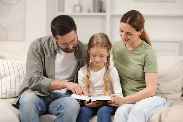 Dziewczyna Jej Rodzice Chrzestni Czytają Biblię Razem Kanapie Domu — Zdjęcie stockowe