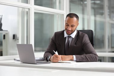 Ofisteki masada çalışan mutlu adam. Avukat, işadamı, muhasebeci ya da yönetici.