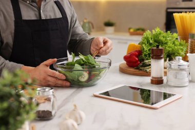 Beyaz mermer tezgahta salata pişiren adam, yakın plan.